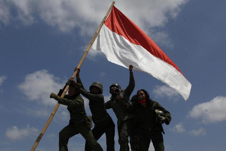 Kakek tua mencium bendera Indonesia